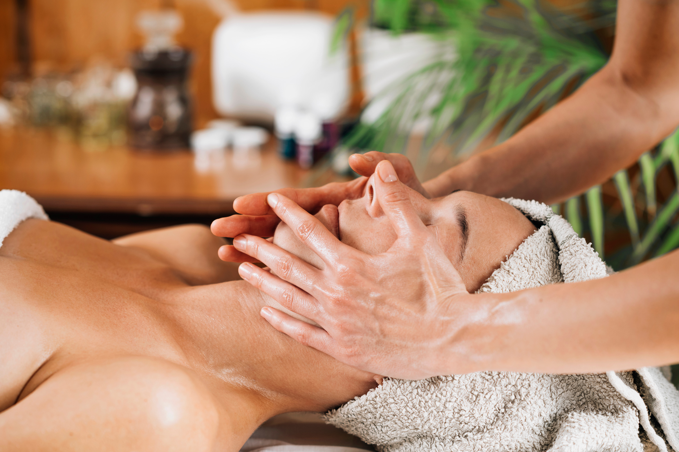 Woman Enjoying A Professional Ayurvedic Facial Massage With Therapeutic Oils